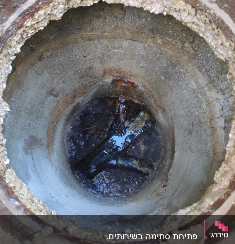 פתח ביוב עם מים עומדים בתחתית